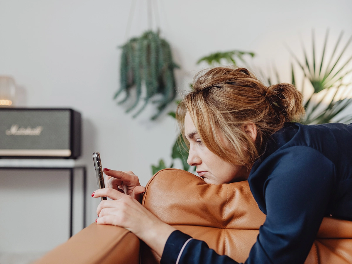 Dame ligt op de bank en vraagt zicht af: Hoe langt duurt het voordat social media werkt?
