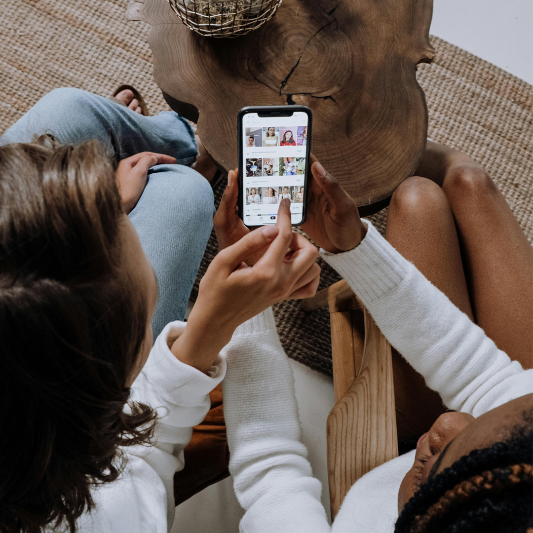 Homepage – sociale media_rooijenburg twee dames met een smartphone laten sociale media posts zien