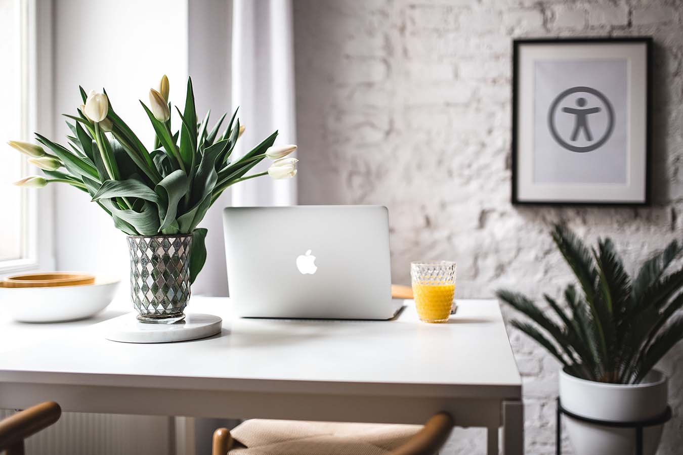 Laptop op tafel. Poster aan de muur met het logo van toegankelij Telefoon met instagram plaatjes voor de 5x5 social media contentstrategie