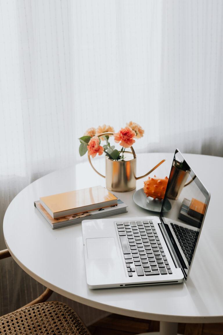 Bureau met laptop en oranje bloemen, de kleur van Rooij & Burg